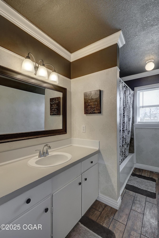 full bathroom featuring wood tiled floor, shower / bath combo with shower curtain, a textured ceiling, and vanity