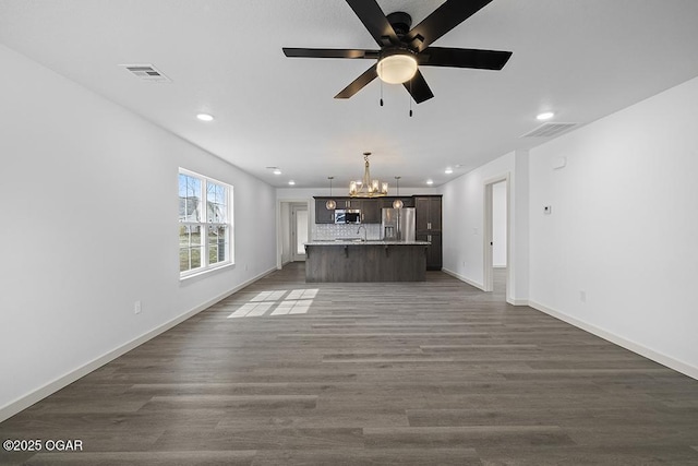 unfurnished living room featuring visible vents, baseboards, recessed lighting, ceiling fan with notable chandelier, and dark wood-style flooring