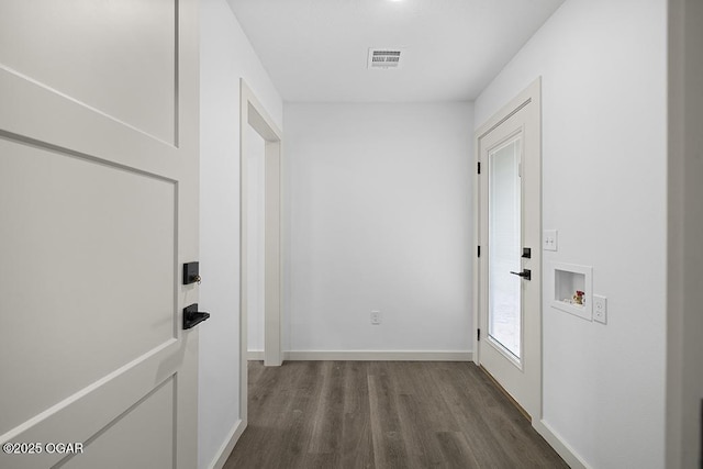 hall with baseboards, visible vents, and dark wood-style flooring