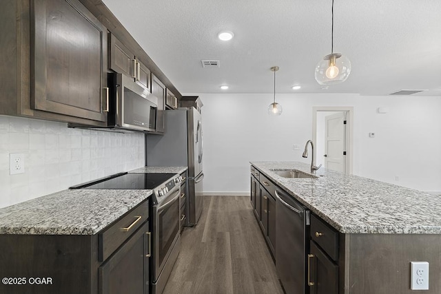 kitchen featuring visible vents, dark wood finished floors, a sink, appliances with stainless steel finishes, and backsplash