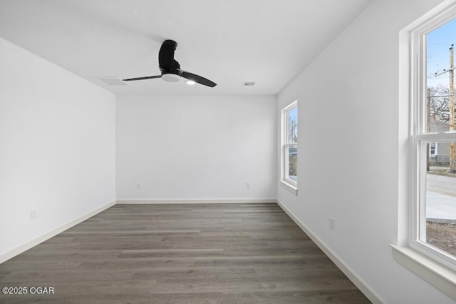 spare room with visible vents, baseboards, wood finished floors, and a ceiling fan