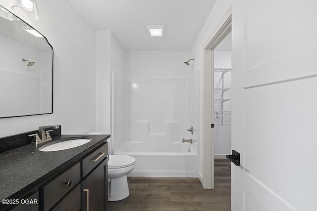 full bathroom with vanity, washtub / shower combination, toilet, and wood finished floors