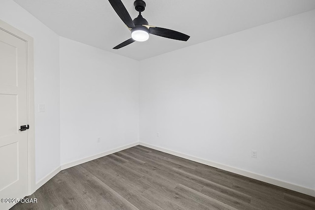 unfurnished room featuring dark wood finished floors, a ceiling fan, and baseboards