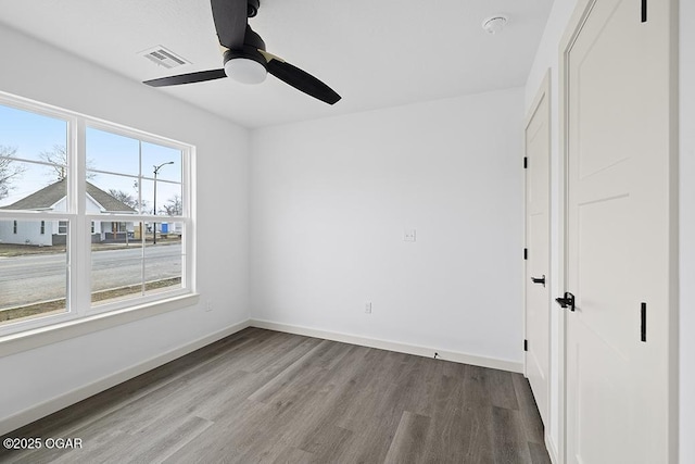 unfurnished bedroom with visible vents, baseboards, wood finished floors, and a ceiling fan