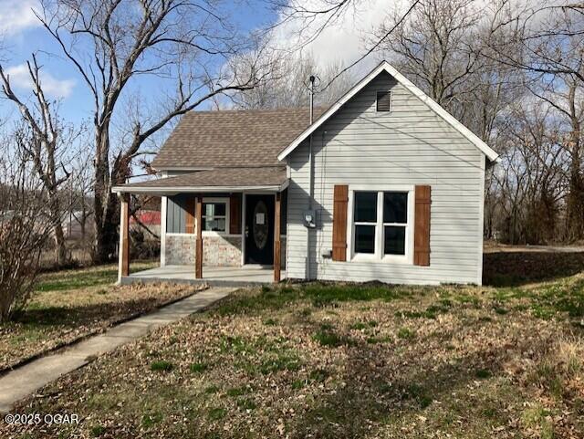 view of front of property with covered porch and roof with shingles