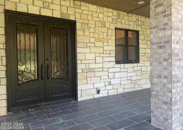 doorway to property featuring french doors and brick siding