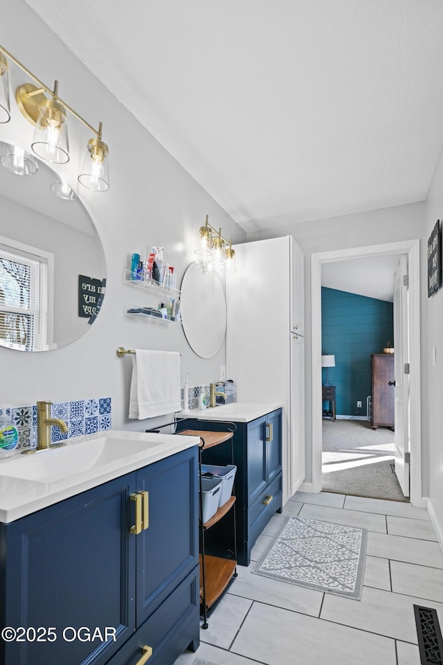 bathroom featuring a sink, visible vents, and two vanities