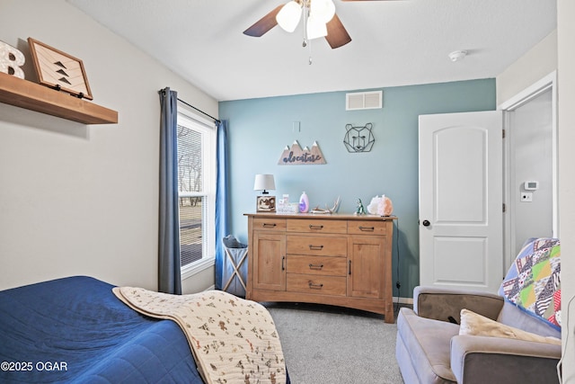 bedroom featuring visible vents, light colored carpet, and ceiling fan