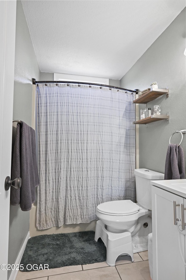 bathroom with tile patterned floors, toilet, vanity, and a textured ceiling