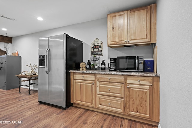 kitchen featuring wood finished floors, recessed lighting, stainless steel fridge with ice dispenser, and visible vents