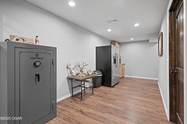 kitchen with light wood finished floors, visible vents, baseboards, recessed lighting, and stainless steel fridge