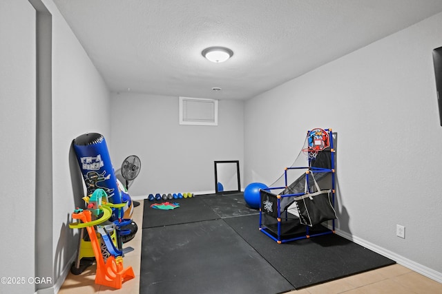 workout area with a textured ceiling and baseboards