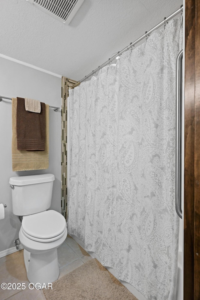 full bath featuring curtained shower, tile patterned floors, toilet, and a textured ceiling