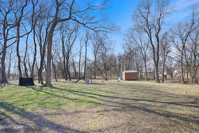 view of yard featuring playground community, an outdoor structure, and a shed