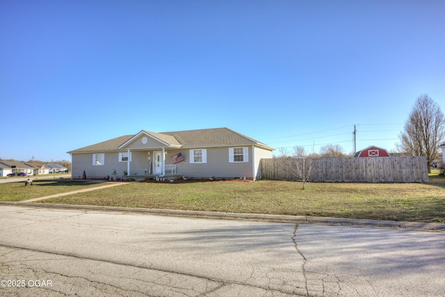 ranch-style home with a front lawn and fence