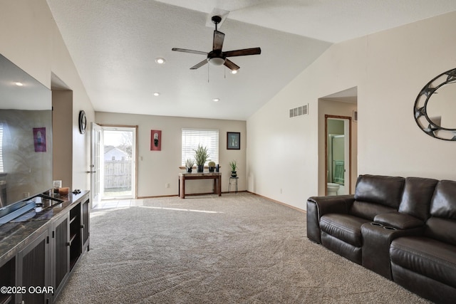 living room with visible vents, baseboards, vaulted ceiling, light carpet, and a ceiling fan