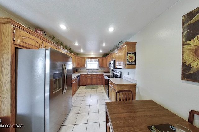 kitchen featuring light tile patterned flooring, recessed lighting, a sink, light countertops, and appliances with stainless steel finishes