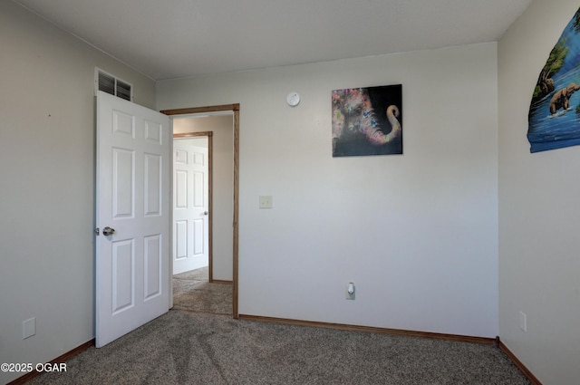 spare room featuring baseboards, visible vents, and carpet floors