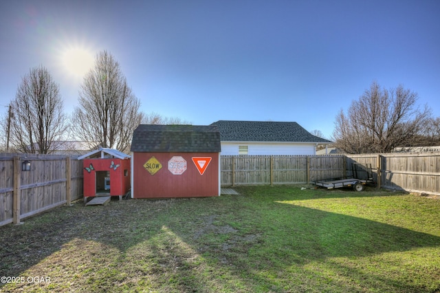 view of yard with an outbuilding, a storage unit, and a fenced backyard