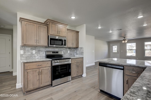 kitchen with light wood-style floors, visible vents, tasteful backsplash, and appliances with stainless steel finishes