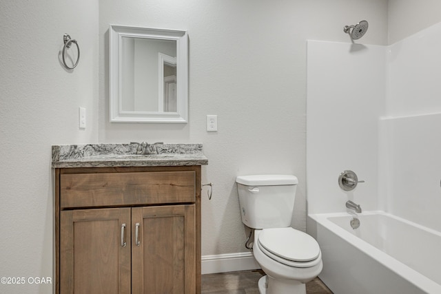 bathroom featuring vanity, wood finished floors, baseboards, shower / bath combination, and toilet