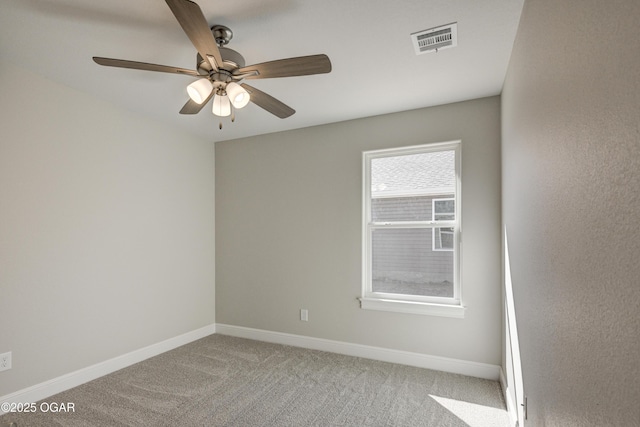 carpeted empty room with a ceiling fan, baseboards, and visible vents