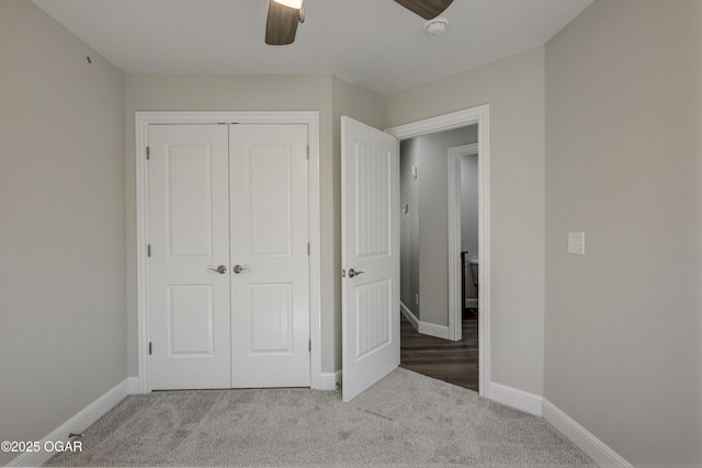 unfurnished bedroom with a closet, baseboards, carpet, and a ceiling fan