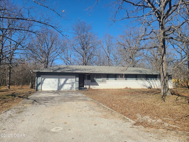 view of front of home with driveway, brick siding, and an attached garage