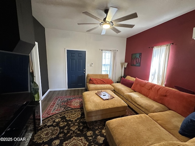 living area featuring baseboards, a ceiling fan, and wood finished floors