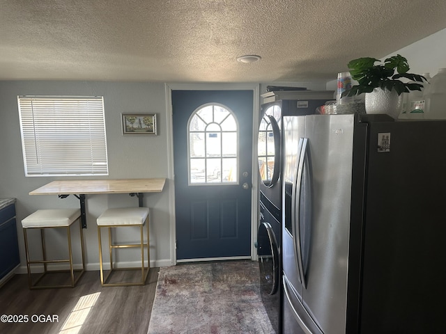 interior space featuring baseboards, a textured ceiling, washer / dryer, and dark wood-style flooring