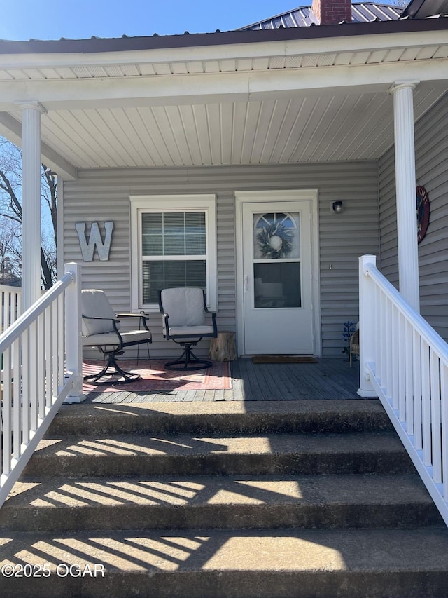 entrance to property with metal roof and a porch