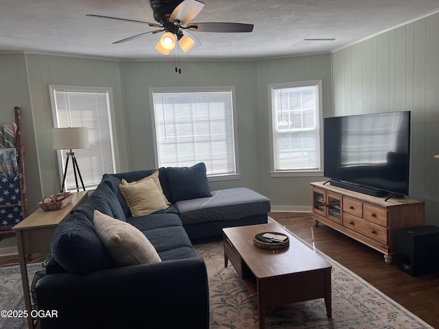 living room with baseboards, ceiling fan, wood finished floors, and ornamental molding