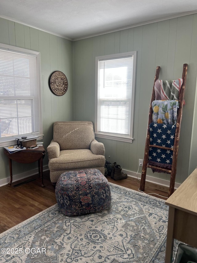 sitting room featuring crown molding, baseboards, and wood finished floors