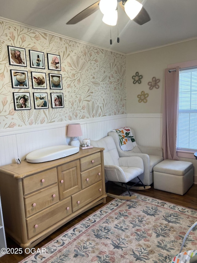 bedroom with wallpapered walls, wainscoting, and wood finished floors