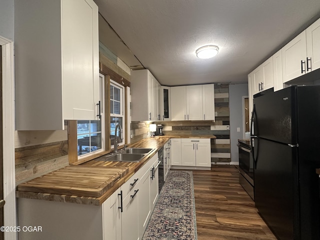 kitchen featuring white cabinetry, a sink, stainless steel appliances, and dark wood-style floors
