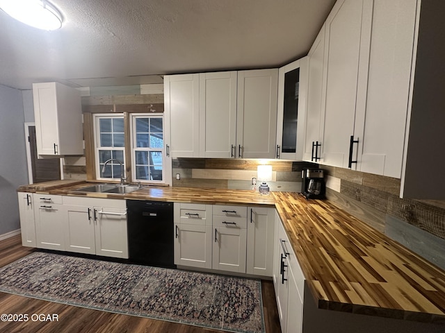 kitchen with black dishwasher, butcher block counters, a sink, and dark wood-type flooring