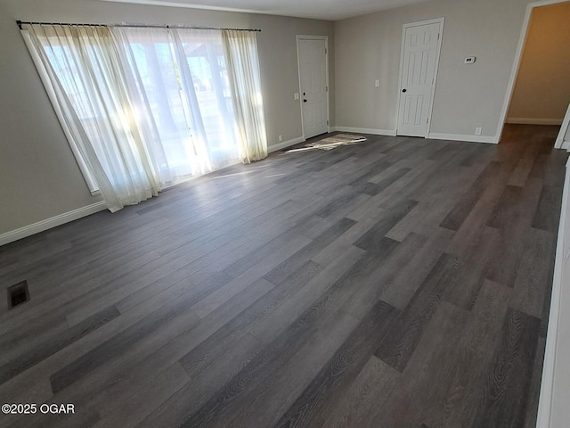 interior space featuring dark wood finished floors, visible vents, and baseboards