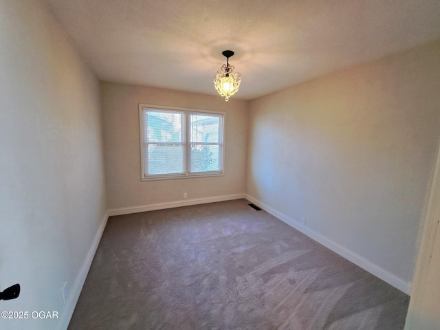 unfurnished room with visible vents, carpet, baseboards, and a chandelier