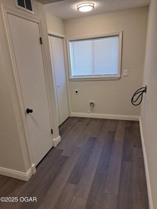 laundry room featuring baseboards, dark wood-style floors, visible vents, and electric dryer hookup