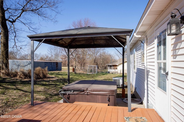 wooden terrace with a gazebo, cooling unit, a yard, and a hot tub