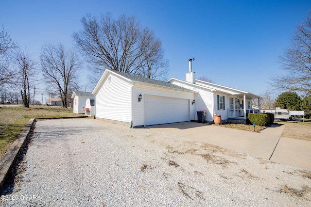 ranch-style home with a porch, an attached garage, driveway, and a chimney