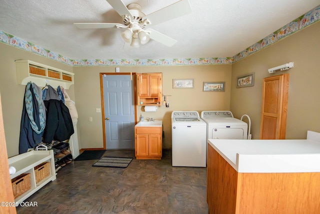 washroom with washing machine and clothes dryer, ceiling fan, cabinet space, a textured ceiling, and a sink