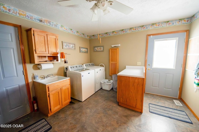 clothes washing area featuring washing machine and dryer, cabinet space, a textured ceiling, a ceiling fan, and a sink