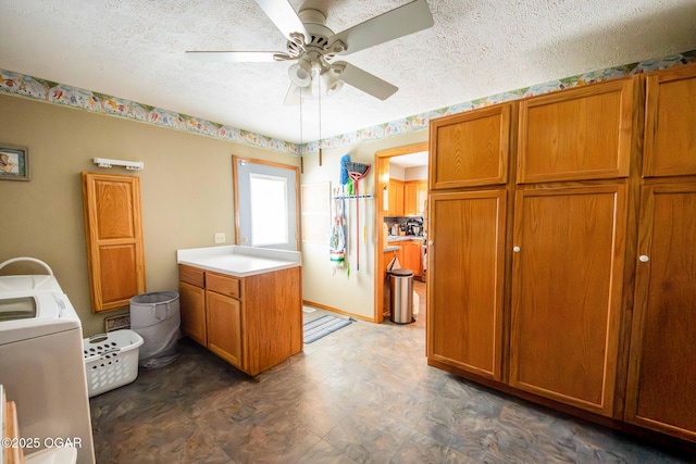 kitchen featuring a textured ceiling, washer / dryer, brown cabinetry, and light countertops