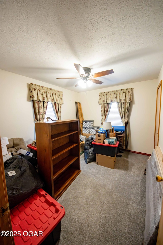 bedroom featuring baseboards, a textured ceiling, a ceiling fan, and carpet floors