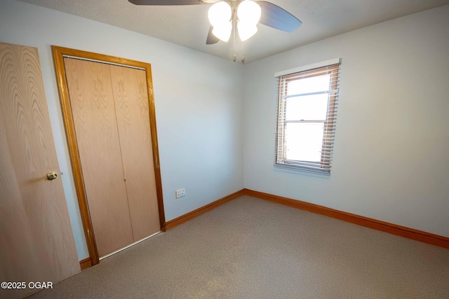 unfurnished bedroom featuring ceiling fan, baseboards, a closet, and carpet floors