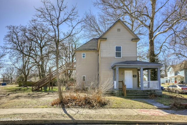 traditional-style house featuring stairway, a porch, and a shingled roof