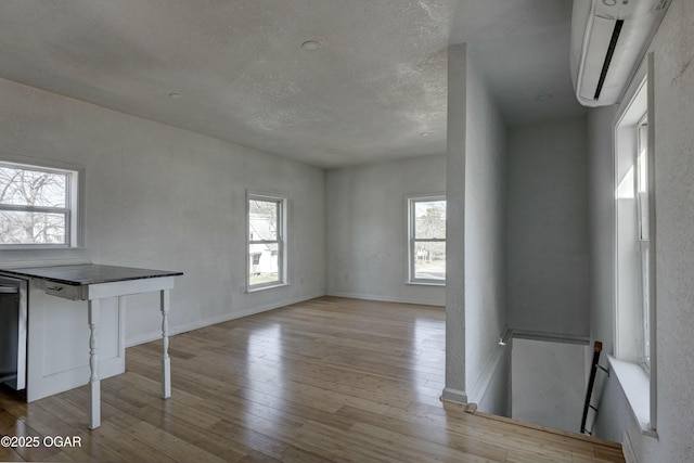 interior space with plenty of natural light, baseboards, and wood finished floors