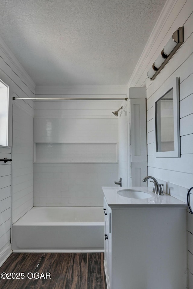 bathroom with vanity, wood finished floors, shower / bathtub combination, and a textured ceiling