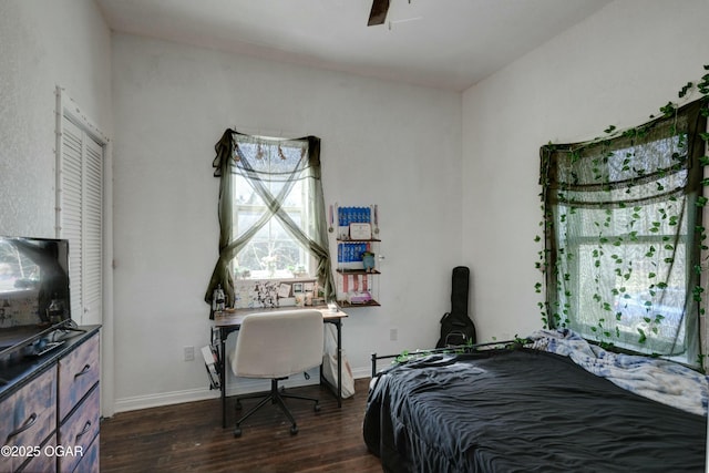 bedroom with dark wood-type flooring and baseboards